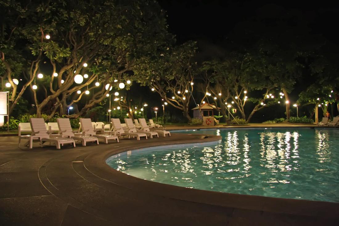 Picture of lounge chairs sitting nicely on stamped concrete pool deck at night